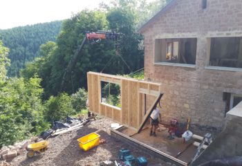 Extension en bois d’une maison en pierre levage façade