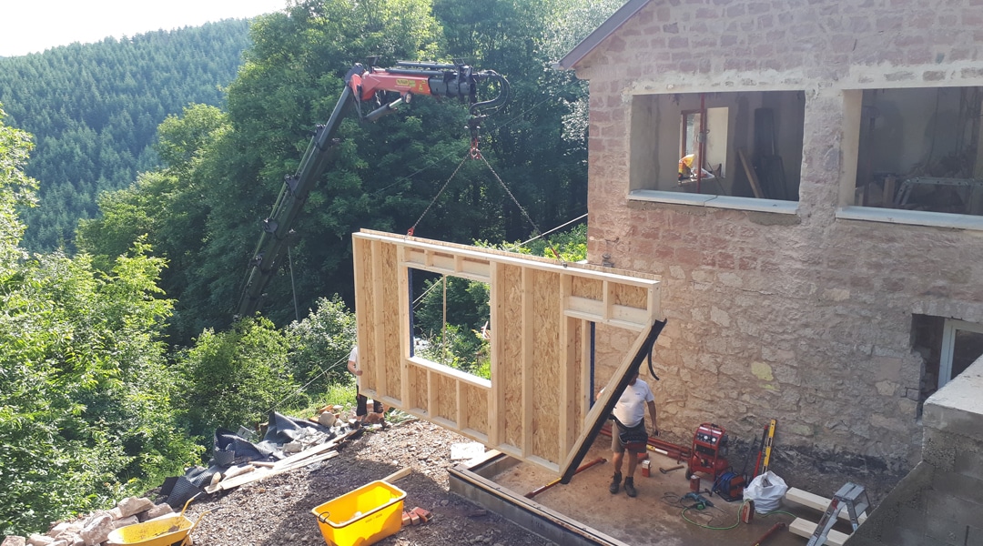 Extension en bois d'une maison en pierre levage façade slide